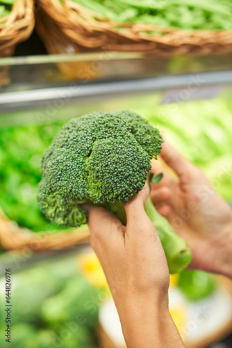 Fresh broccoli in hands of customer
