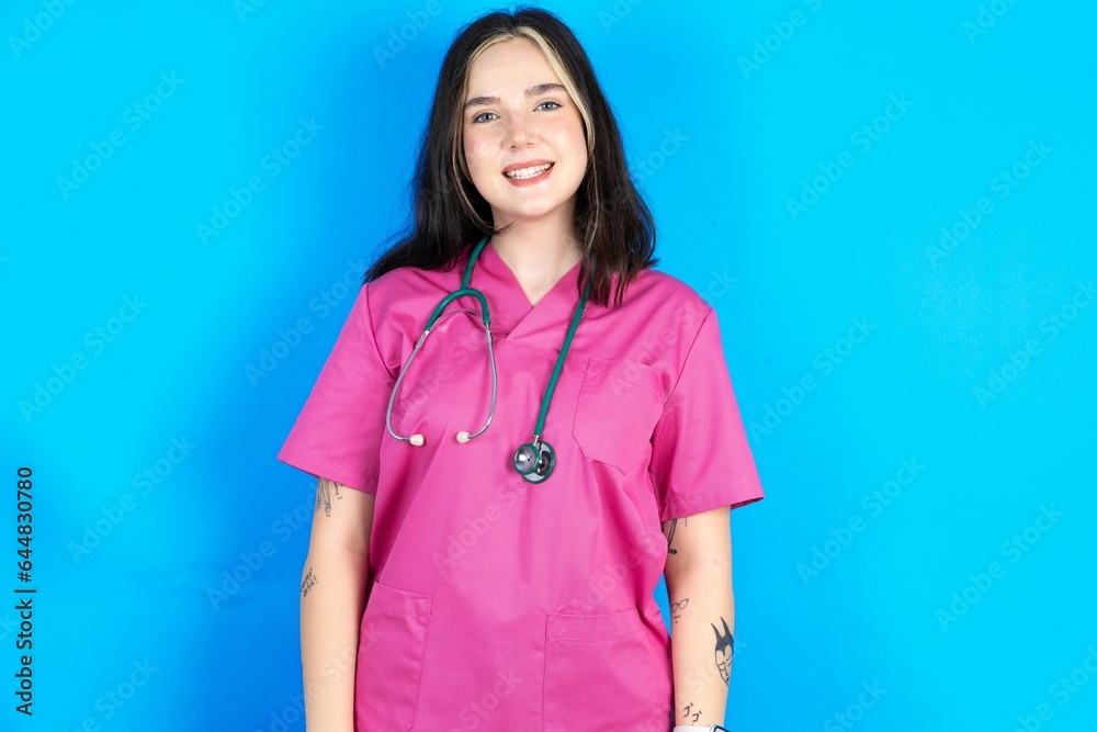 Young caucasian doctor woman wearing pink medical uniform with a happy and cool smile on face. Lucky person. Young caucasian doctor woman wearing pink medical uniform with a happy and cool smile on face. Lucky person.