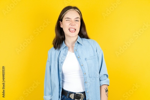 Beautiful woman wearing casual clothes sticking tongue out happy with funny expression. Emotion concept. photo
