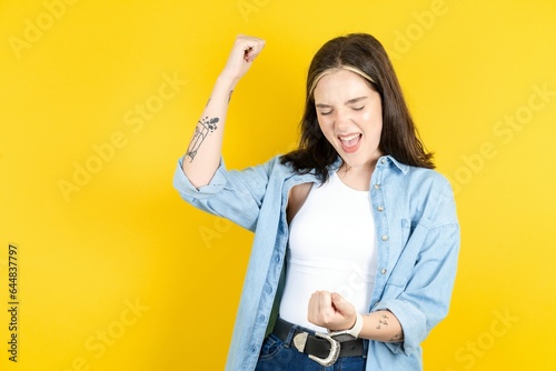 Profile photo of excited Beautiful woman wearing casual clothes good mood raise fists screaming rejoicing overjoyed basketball sports fan supporter