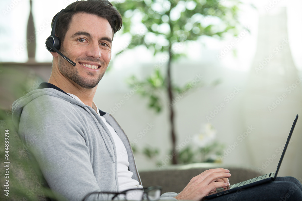 Fototapeta premium handsome man wearing headset and using a laptop