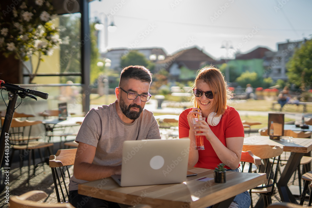 Two people man and woman working on laptop in cafe, modern business and lifestyle concept