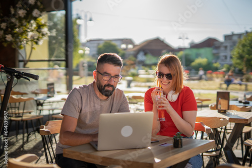 Two people man and woman working on laptop in cafe, modern business and lifestyle concept