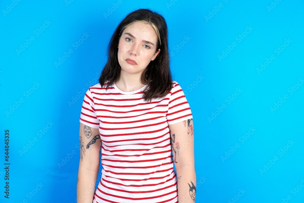 beautiful young woman wearing striped T-shirt depressed and worry for distress, crying angry and afraid. Sad expression. beautiful young woman wearing striped T-shirt depressed and worry for distress, crying angry and afraid. Sad expression.
