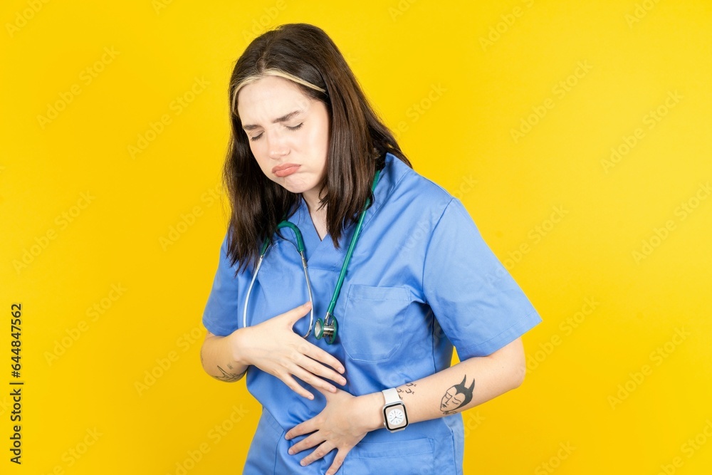 Young caucasian doctor woman wearing blue medical uniform got stomachache Young caucasian doctor woman wearing blue medical uniform got stomachache