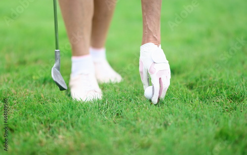 Golfer fixes golf ball and holds golf club in his hand. Golf equipment and intertar concept