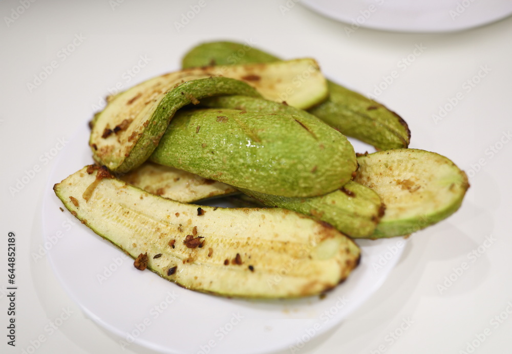 On plate are cooked zucchini with seasoning and garlic. Vegetarianism and diet as lifestyle concept On plate are cooked zucchini with seasoning and garlic. Vegetarianism and diet as lifestyle concept