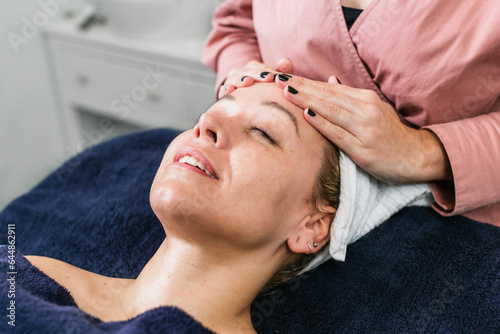 Anonymous masseuse doing massage for woman in spa salon