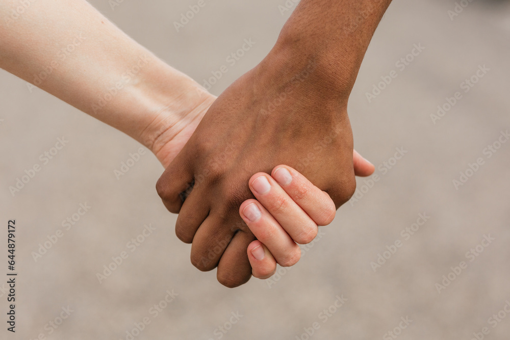 Multiethnic best friends holding hands tenderly Multiethnic best friends holding hands tenderly