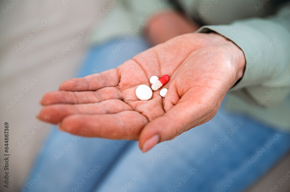 Woman hand with antidepressant pills on her palm Woman hand with antidepressant pills on her palm