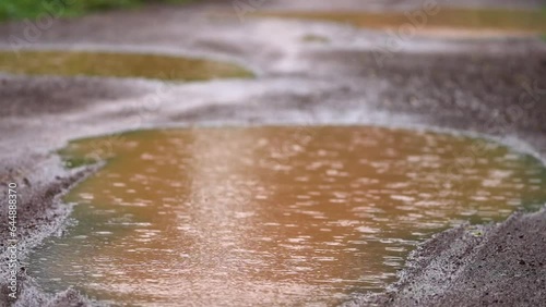 Multiple drips and ripples on bright blue calm water, Rainwater Filling a Roadside Pit on a Murum Road, water stagnation on roads stock video. photo