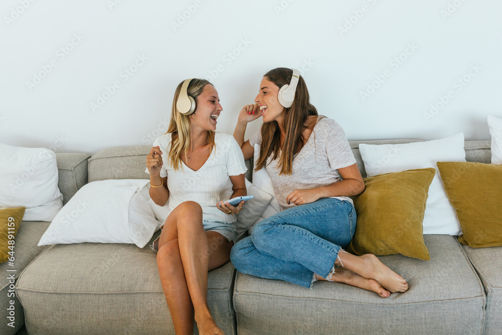 Delighted women singing on couch Delighted women singing on couch
