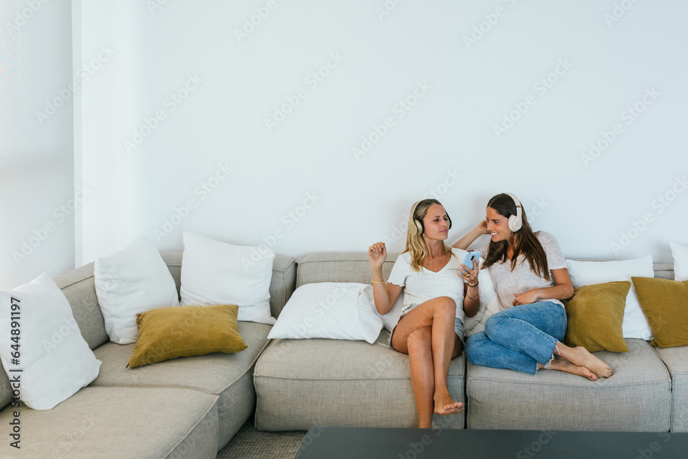 Delighted women singing on couch