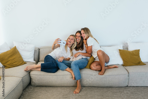 Fototapeta Woman taking a selfie with her sisters
