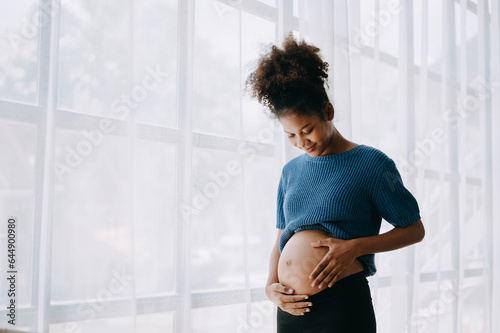 Canvastavla pregnant african american woman at home window white background.