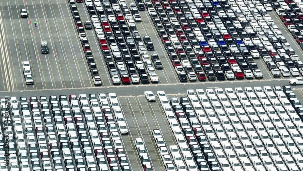 Drone is flown over a factory parking lot filled with many cars, it would aim to capture a variety of shots showcasing the cars in different positions and angles. Logistics industry. vehicles concept
Drone is flown over a factory parking lot filled with many cars, it would aim to capture a variety of shots showcasing the cars in different positions and angles. Logistics industry. vehicles concept