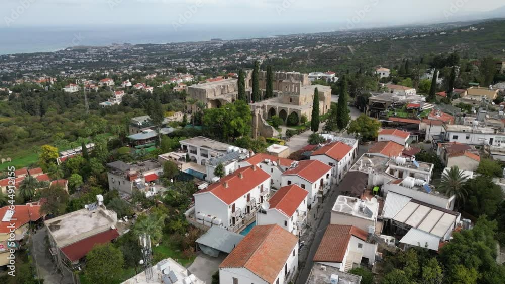 Drone flight over residential neighborhood towards the ruins of Bellapais Abbey monastery, religion and historic architecture in North Cyprus Drone flight over residential neighborhood towards the ruins of Bellapais Abbey monastery, religion and historic architecture in North Cyprus