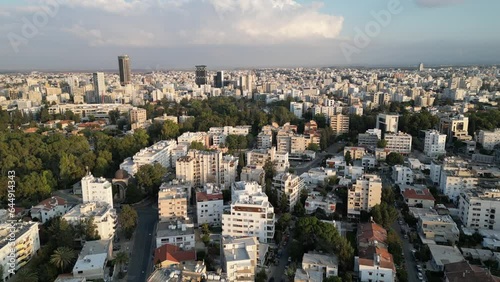 Establishing drone flight over apartment towers in residential neighborhood, flying towards offices and other buildings, skyline of city center of Nicosia (South)
