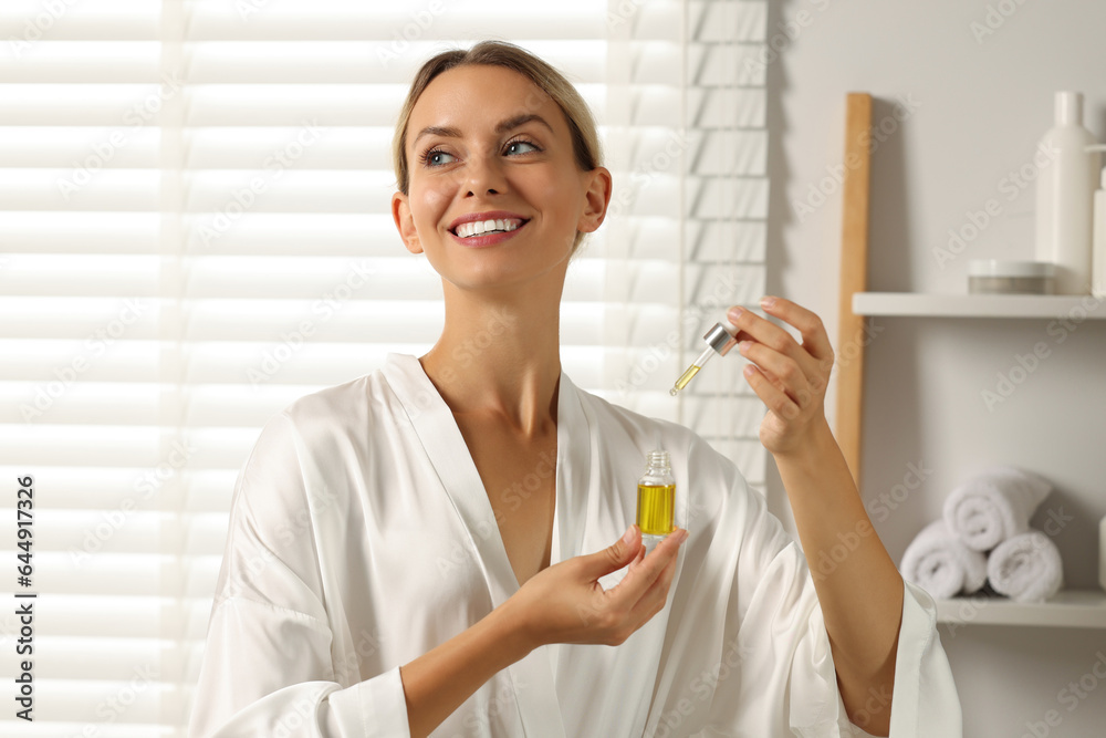 Beautiful woman with cosmetic serum in her hands in bathroom Beautiful woman with cosmetic serum in her hands in bathroom