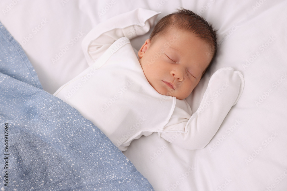 Cute newborn baby sleeping under blue blanket on bed, top view Cute newborn baby sleeping under blue blanket on bed, top view