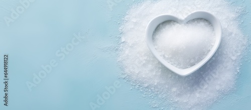 Heart shaped plate with sea salt viewed from above on a isolated pastel background Copy space with clipping path photo