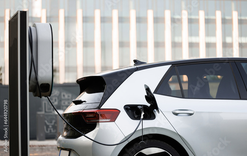 Charge station for electric cars. Electric car charger. Alternative energy for ecological cars. Electric, zero pollution cars on green energy concept on modern city parking lot