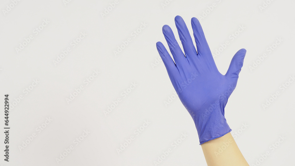 Obraz premium Empty Hand is wearing violet latex gloves on white background.