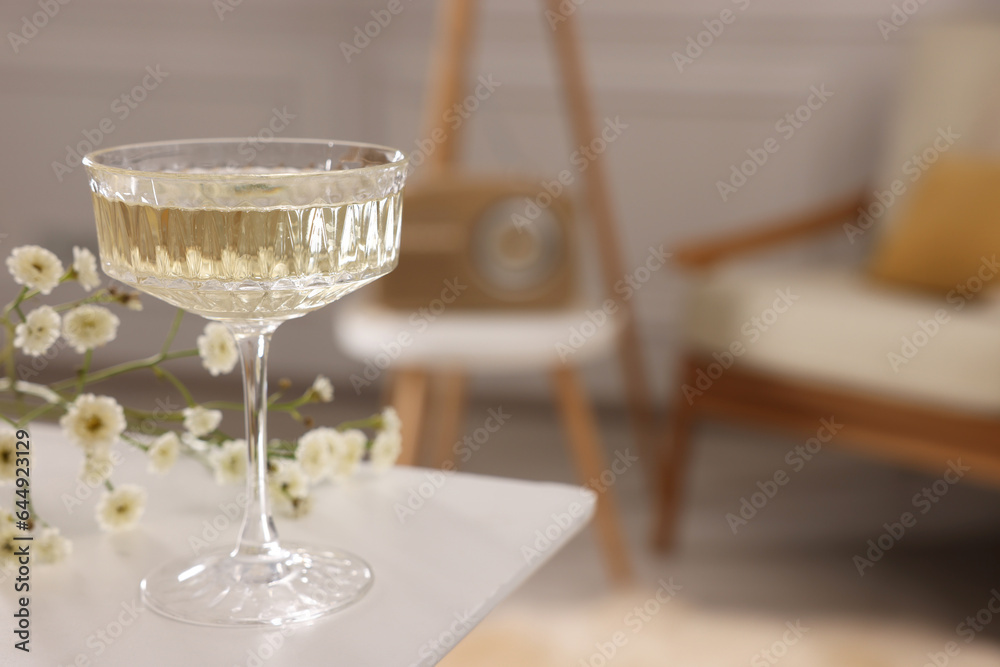 Glass of alcohol drink on table in room, space for text. Relax at home Glass of alcohol drink on table in room, space for text. Relax at home