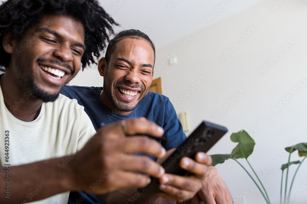 Two afro american boys laughing while they are looking something at the mobile phone Two afro american boys laughing while they are looking something at the mobile phone