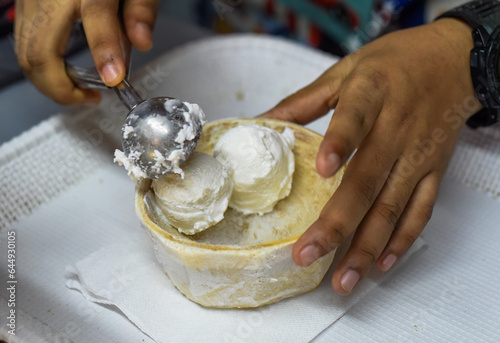 Photography Hand holding coconut and mango ice cream in coconut shell in Jalan Alor street f
