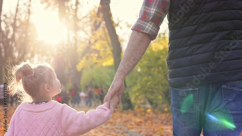 Happy family. Father and daughter walking in autumn park. Cute kid and dad having fun, enjoy spending time together. Happy carefree childhood. Close up back view.