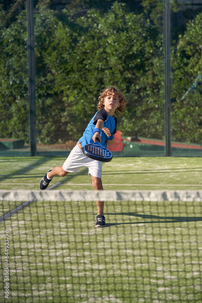 Boy playing padel on sports ground