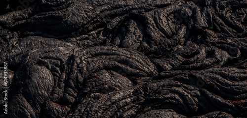 The lava surface cools and hardens into rock Clumps of dark black lava