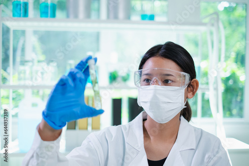 Scientist picking up cucumber tissue test tube for experiment or research of body skin care, cosmetic, treatment, serum or medical moisturizer essence. Developing quality of product in laboratory.