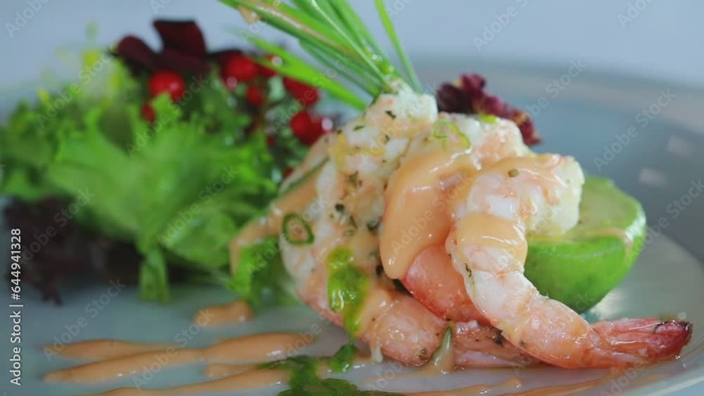 Professional chef pouring green sauce over shrimps in a delicious plate for dinner. Professional chef pouring green sauce over shrimps in a delicious plate for dinner.