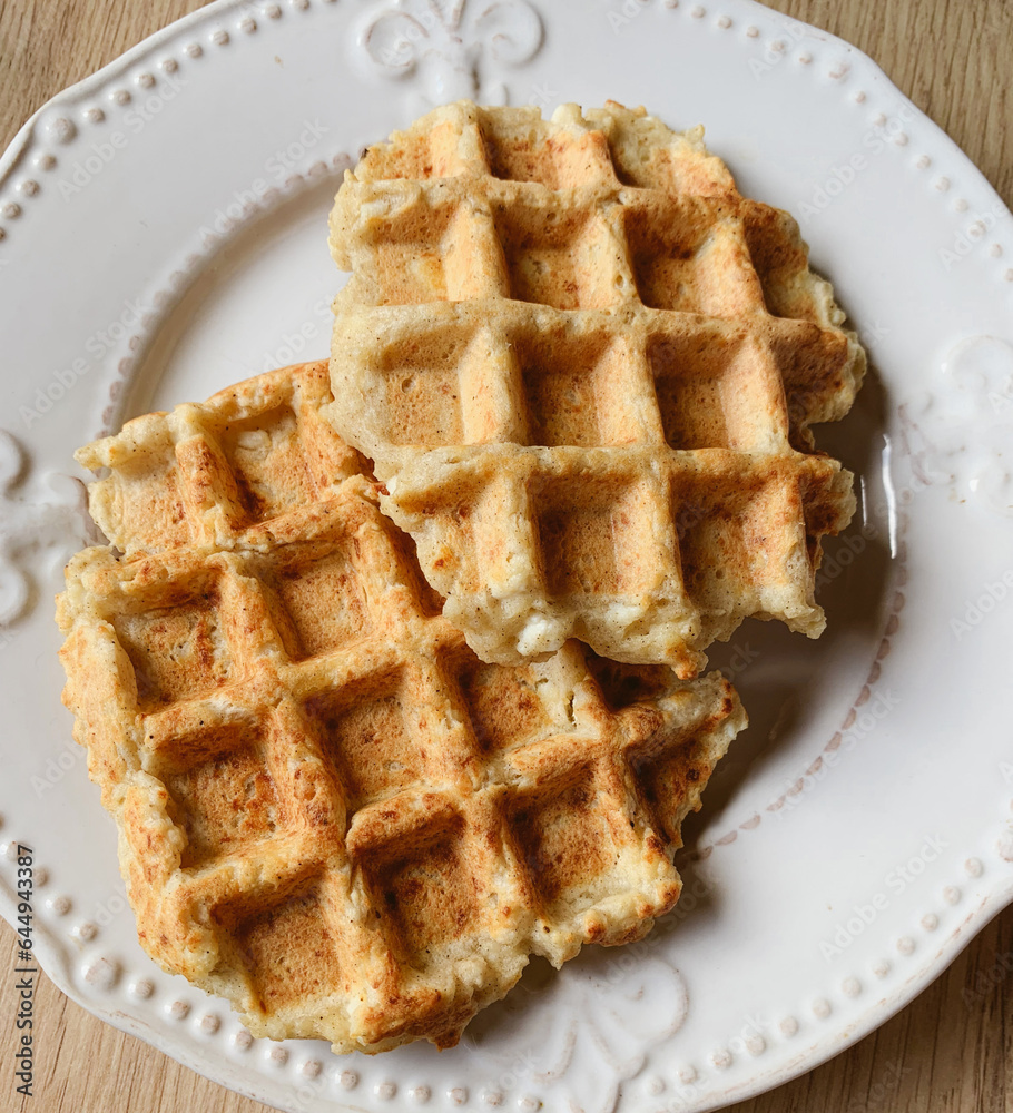Delicious freshly cooked healthy ricotta waffles on white plate, close up. Delicious freshly cooked healthy ricotta waffles on white plate, close up.