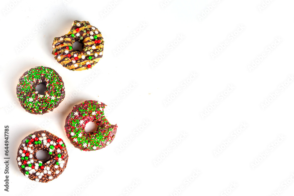 Bright festive decorated Christmas and New Year donuts set, with colorful red, green white snowflake sugar sprinkles. Sweet seasonal Christmas dessert