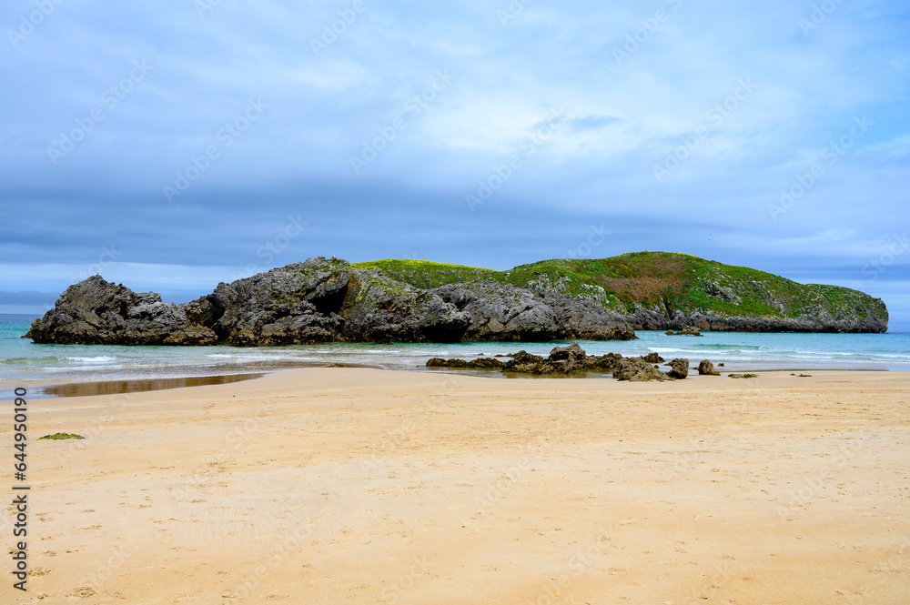 View on Playa de Borizo in Celorio, Green coast of Asturias, North Spain with sandy beaches, cliffs, hidden caves, green fields and mountains.