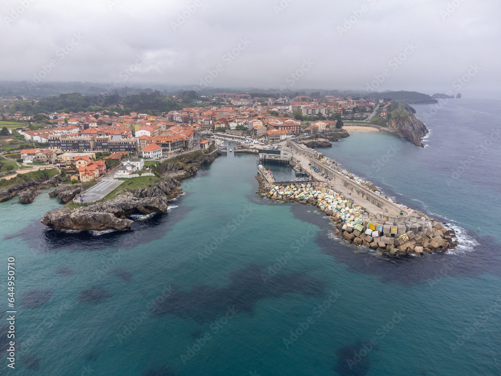 Aerial view on Playa de Toro and Llanes old harbour, Green coast of Asturias, North Spain with sandy beaches, cliffs, hidden caves, green fields and mountains.