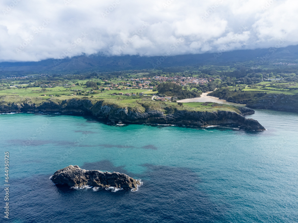 Aerial view on coastline near Llanes, Green coast of Asturias, North Spain with sandy beaches, cliffs, hidden caves, green fields and mountains.