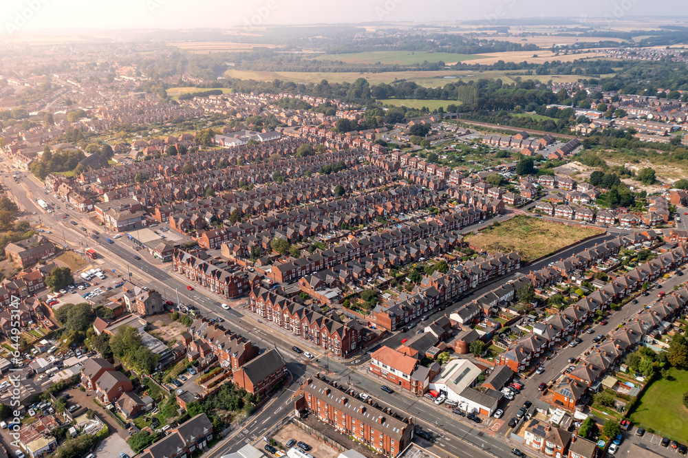 Aerial view above rows of back to back terraced houses on a large council estate