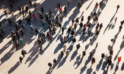 From highly above large crowd of people walking in sunny city square