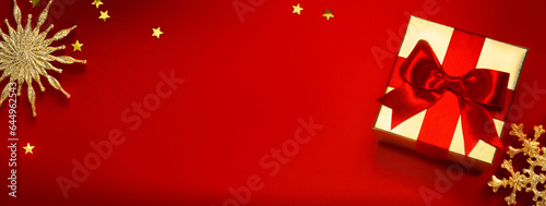 Christmas banner or greeting card background with christmas gift box and golden decoration on red background