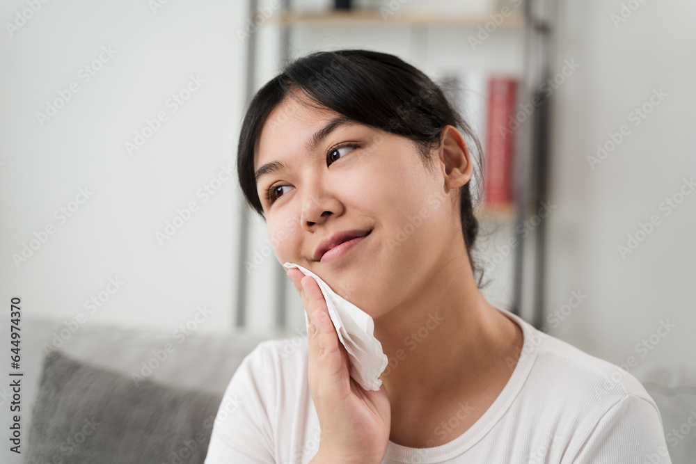 Young Asian woman wiping face with paper towel, Facial Cleansing Wipes, Removing Makeup. Beauty and fashion concept. Young Asian woman wiping face with paper towel, Facial Cleansing Wipes, Removing Makeup. Beauty and fashion concept.