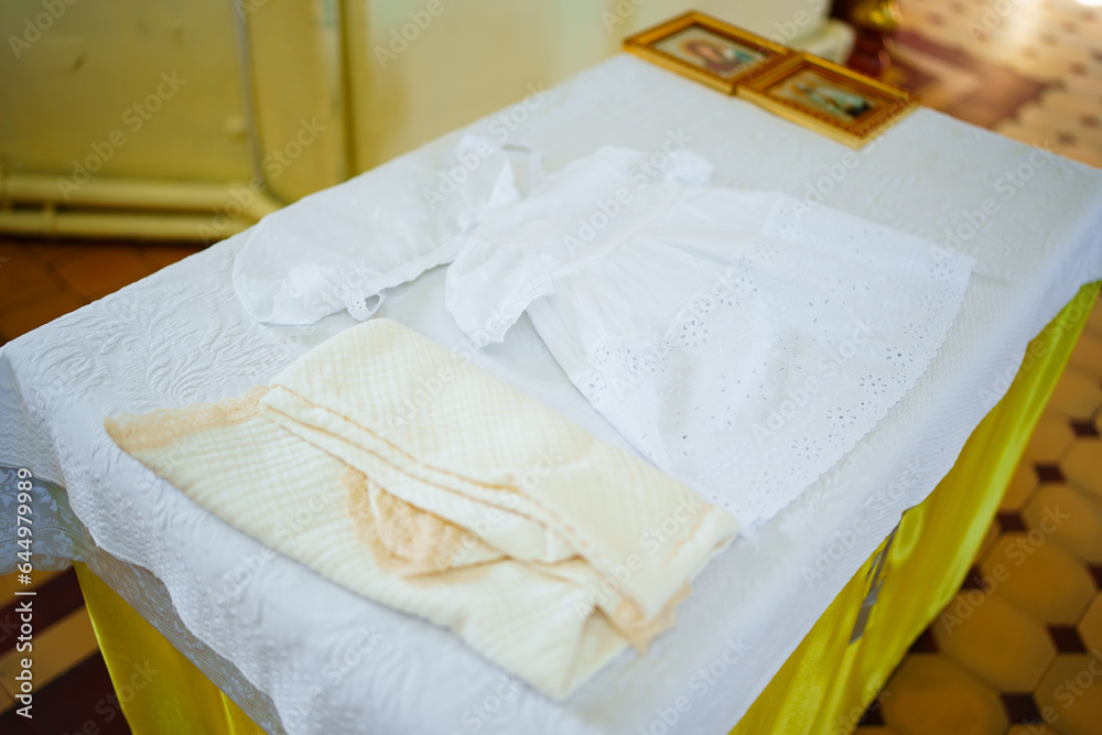 A set of baptismal clothes and a towel on the table in the church. A set of baptismal clothes and a towel on the table in the church.