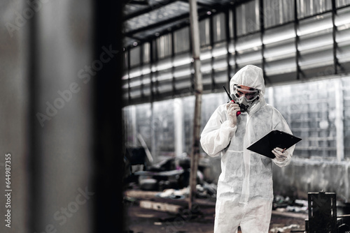 Scientist wear Chemical protection suit check danger chemical, working at dangerous zone in Red and White Lines of barrier tape. Red and white Hazardous restricted area factory safety worker industry