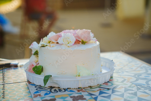 Classic white cake decorated with pink and white fresh flowers. 