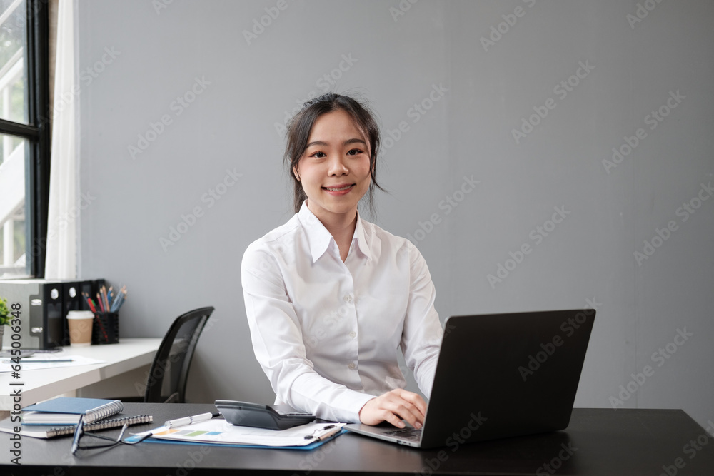 Portrait of Young Successful asian Businesswoman Sitting at Desk Working on Laptop Computer in City Office. Portrait of Young Successful asian Businesswoman Sitting at Desk Working on Laptop Computer in City Office.