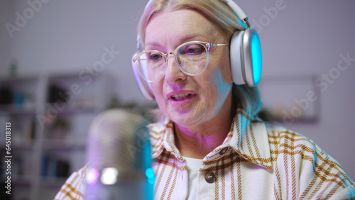 Fotografie Close-up of a beautiful senior woman recording a podcast, working as a radio anc
