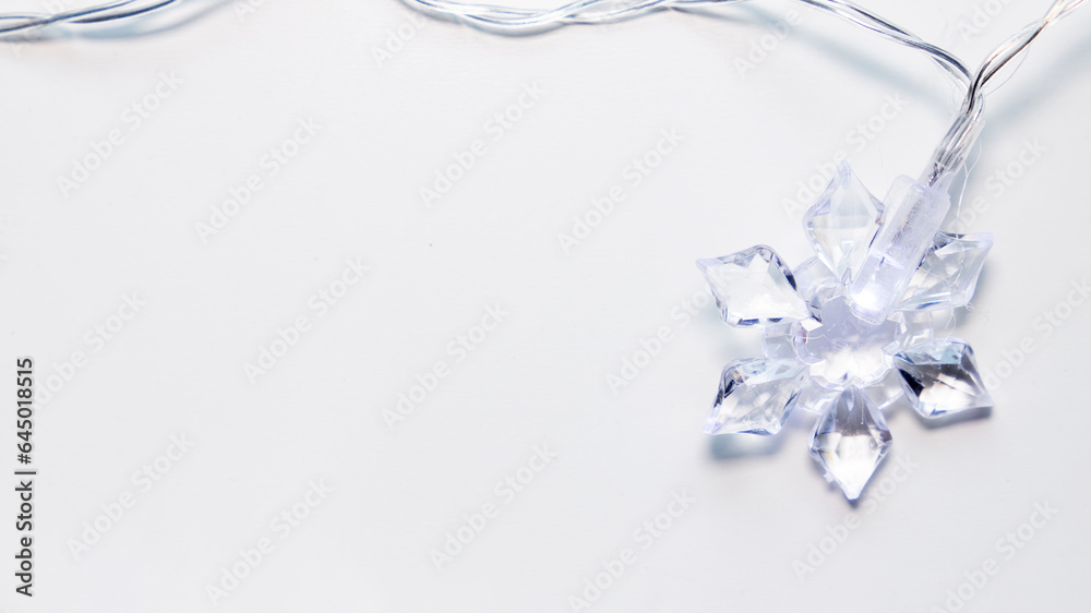 close up of transparent light cable with snowflake-shaped bulb close up of transparent light cable with snowflake-shaped bulb
